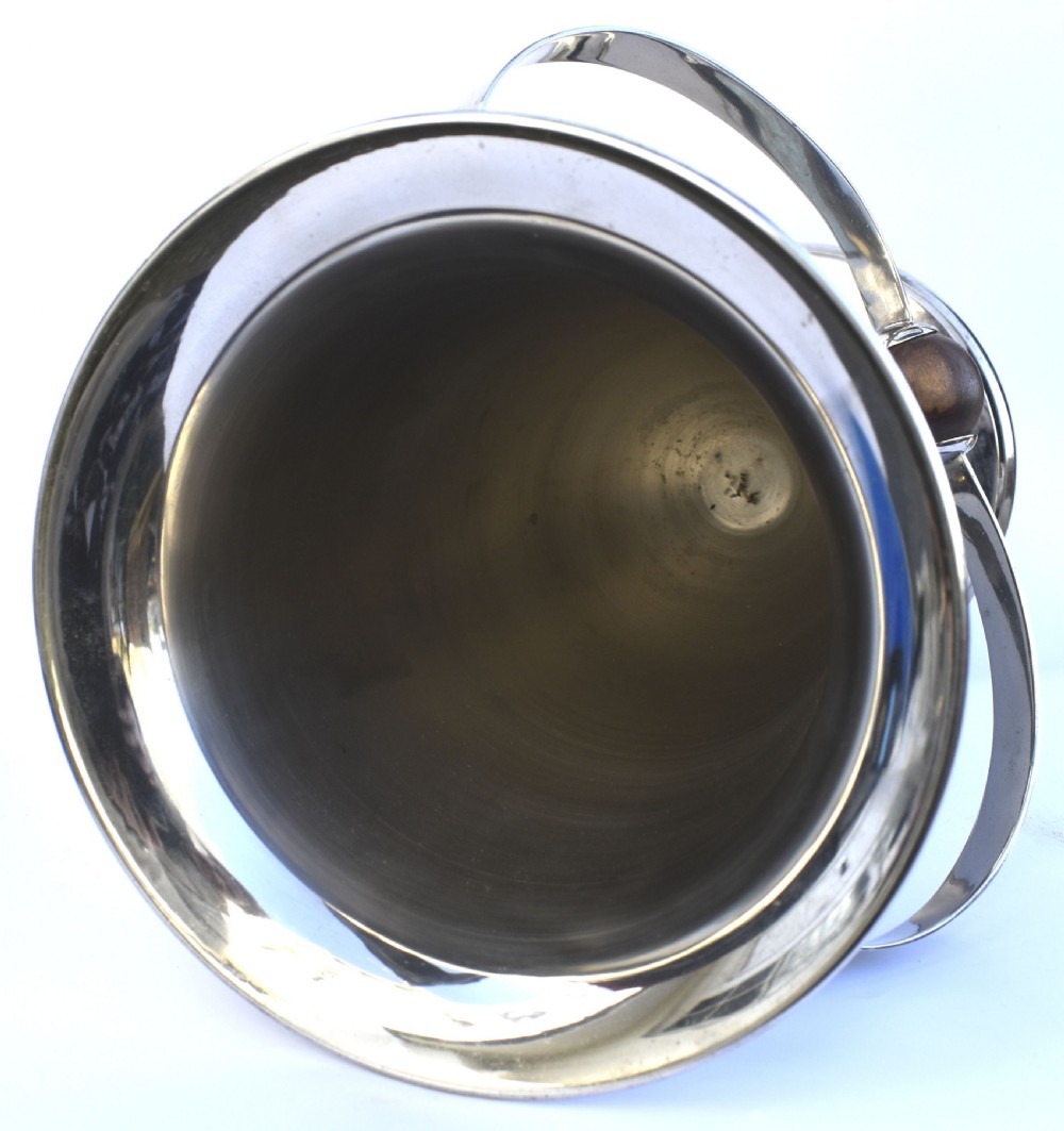 A tall polished chrome ice bucket featuring a pedestal base, flared top rim, and a curved swing handle with a turned wooden centre knob. View IV