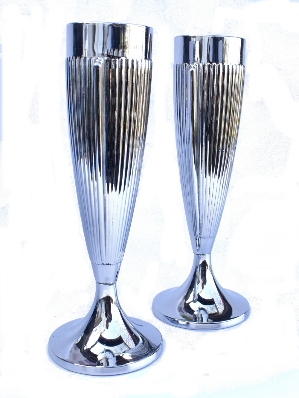 A pair of polished chrome Art Deco vases featuring fluted conical bodies set upon flared pedestal bases. View IV