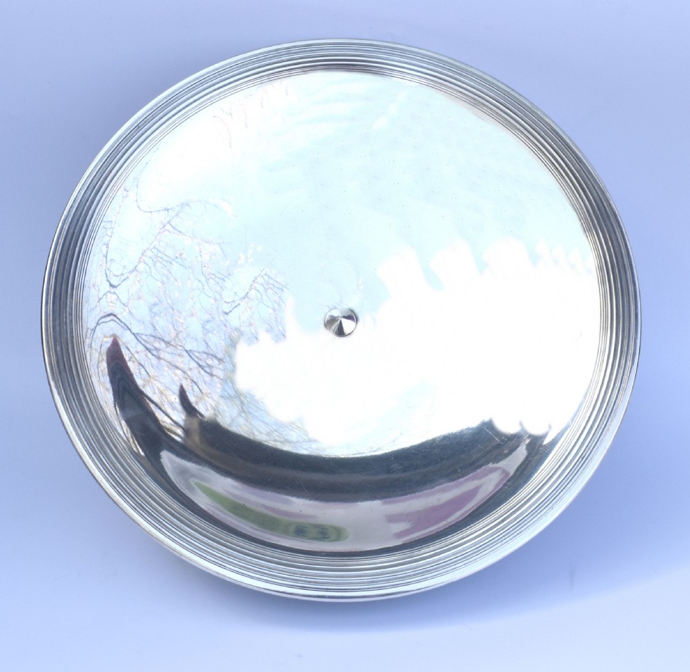 A shallow Art Deco chrome bowl supported by three spherical metal ball feet set on a stepped circular pedestal base. View V