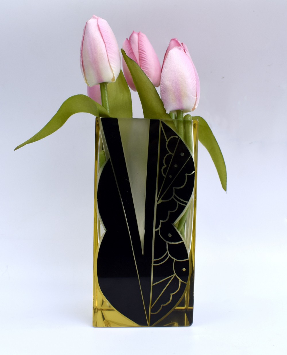 A rectangular Art Deco clear glass vase with a yellow hue, decorated with a stylised geometric black and etched enamel design. View III