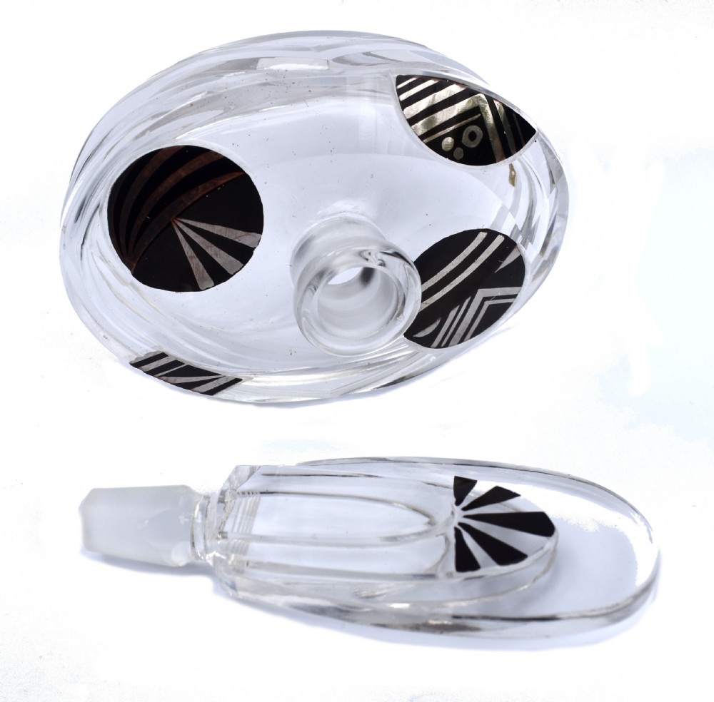 An Art Deco clear glass perfume bottle with angular cut facets, black enamelled fan details, and a matching tall stopper. View IV