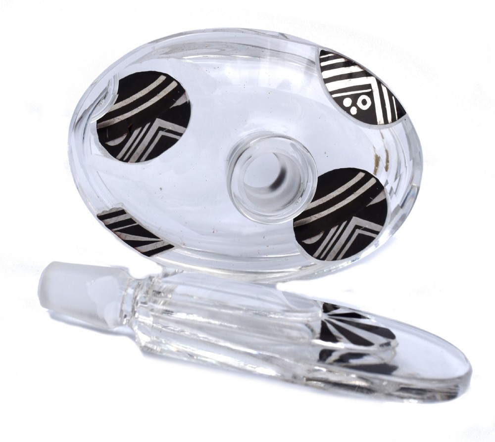 An Art Deco clear glass perfume bottle with angular cut facets, black enamelled fan details, and a matching tall stopper. View V