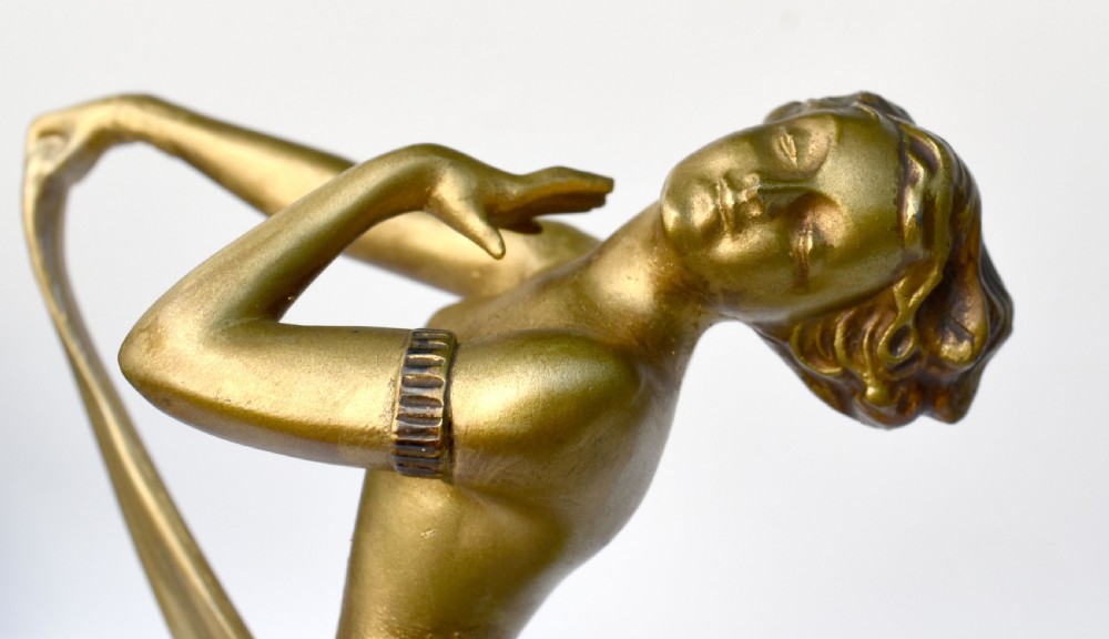 An Art Deco gold-tone spelter sculpture of a stylised female dancer set upon a turned cream alabaster base. View VI
