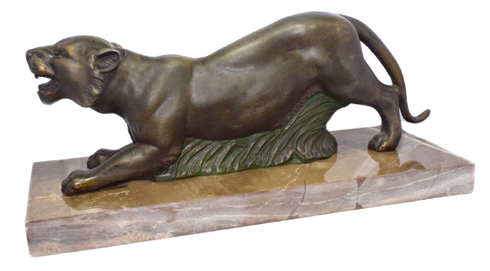 A French Art Deco patinated spelter sculpture depicting a crouching prowling panther with open jaws, mounted on a rectangular veined brown marble base.