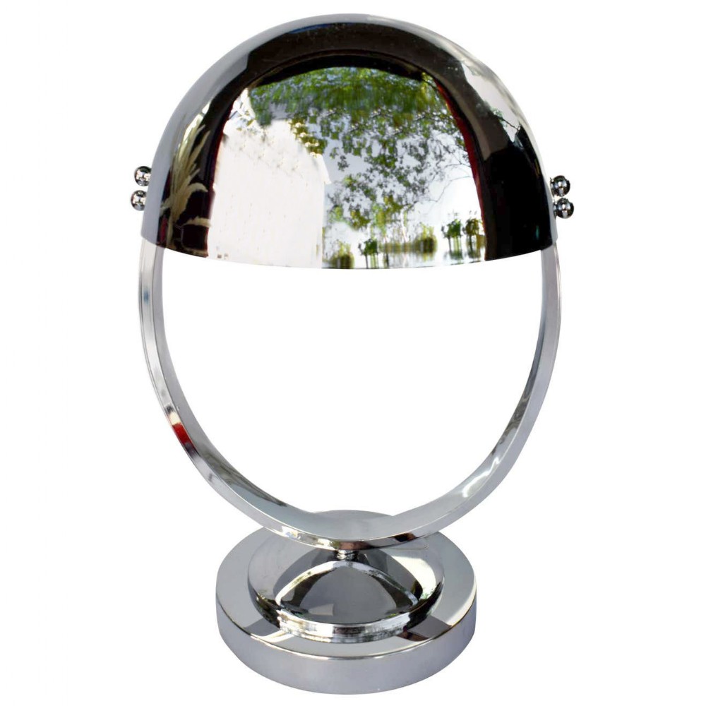A modernist chrome desk lamp featuring an adjustable hemispherical shade suspended inside a circular ring frame above a stepped base.