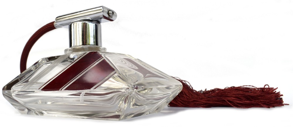 An Art Deco cut clear crystal glass perfume atomizer featuring a burgundy geometric inlay panel, chrome metal fitting, and a maroon fabric bulb with a fringe tassel. View III