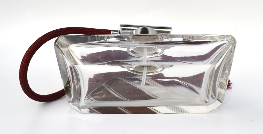 An Art Deco cut clear crystal glass perfume atomizer featuring a burgundy geometric inlay panel, chrome metal fitting, and a maroon fabric bulb with a fringe tassel. View VI