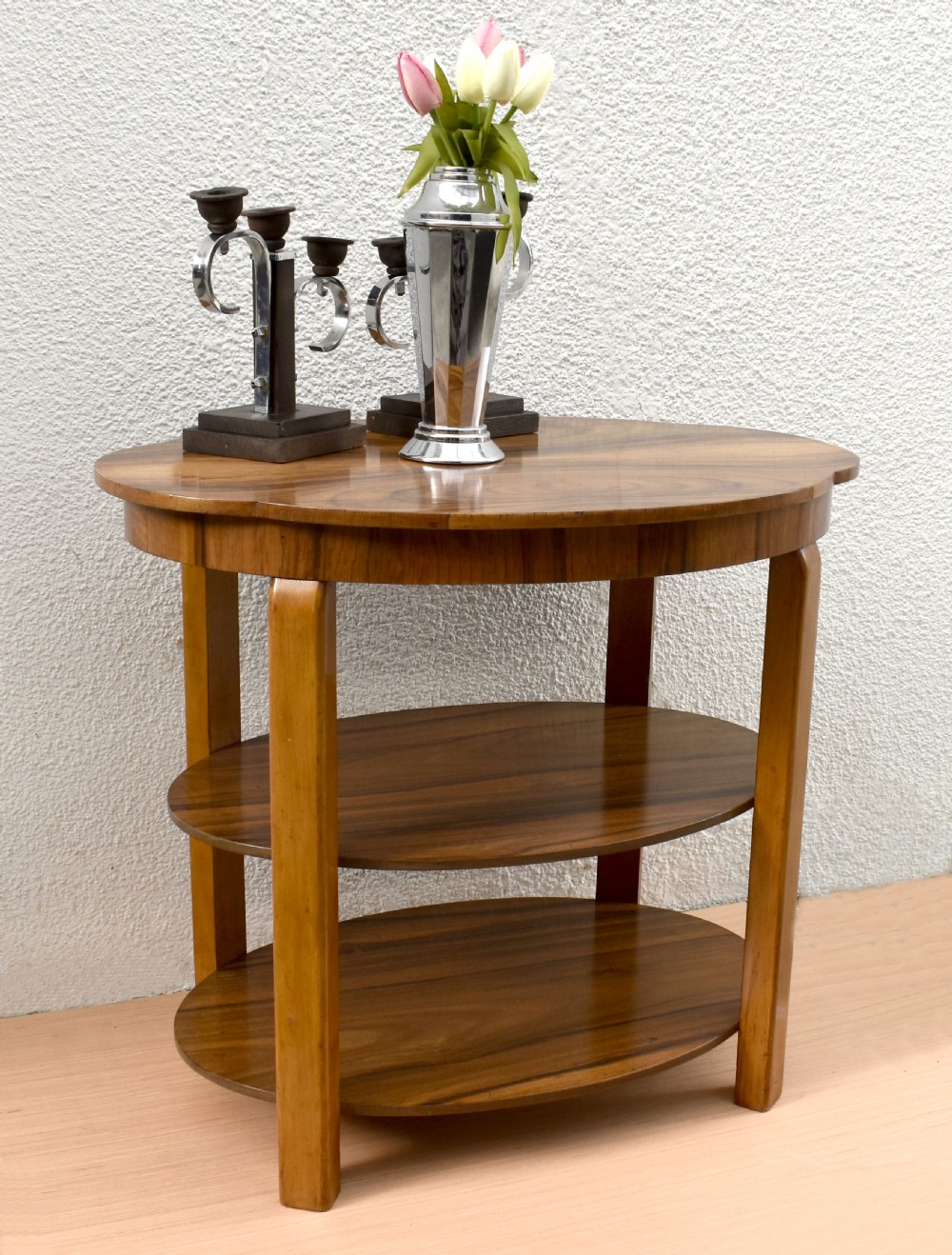 An Art Deco circular three-tier table made of figured walnut with smooth curved support legs. View XI