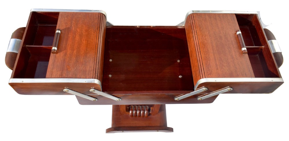An Art Deco wooden cantilever sewing box on a pedestal stand with metallic joint brackets and cylindrical handles. View III