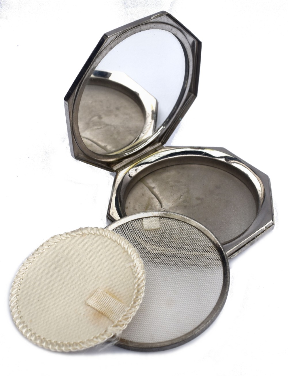 An octagonal Art Deco powder compact featuring terracotta red enamelled side panels and a central faux snakeskin section bordered by brass trim. View IV
