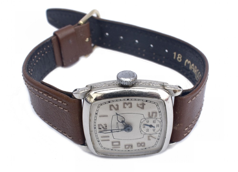 An Art Deco Elgin gentlemans wrist watch featuring a cushion-shaped 14k white gold case, cream dial with black Arabic numerals, small seconds dial, and a stitched brown leather strap. View IV
