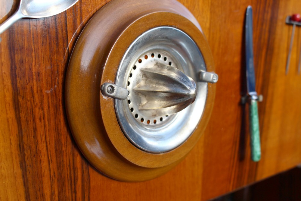 An Art Deco walnut cocktail cabinet featuring figure-matched timber grain, a drop-front upper section, double lower doors, and streamlined handles. View VII