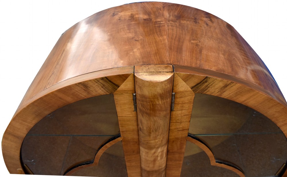 A circular Art Deco walnut display cabinet featuring glazed doors with geometric wooden glazing bars and a contoured base. View VII