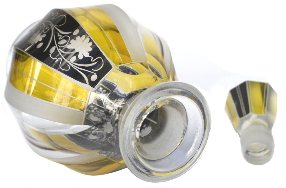 A faceted clear glass Art Deco perfume bottle with yellow and black geometric stained panels, floral etching, and a matching faceted geometric stopper. View III
