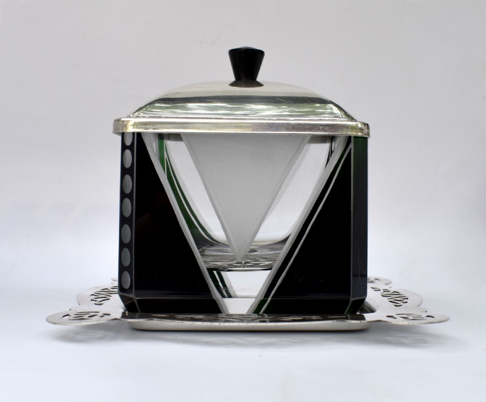 An Art Deco glass preserve dish featuring black and frosted geometric triangular motifs, topped with a silver-plated square lid and set on a pierced silver-plated tray. View VIII