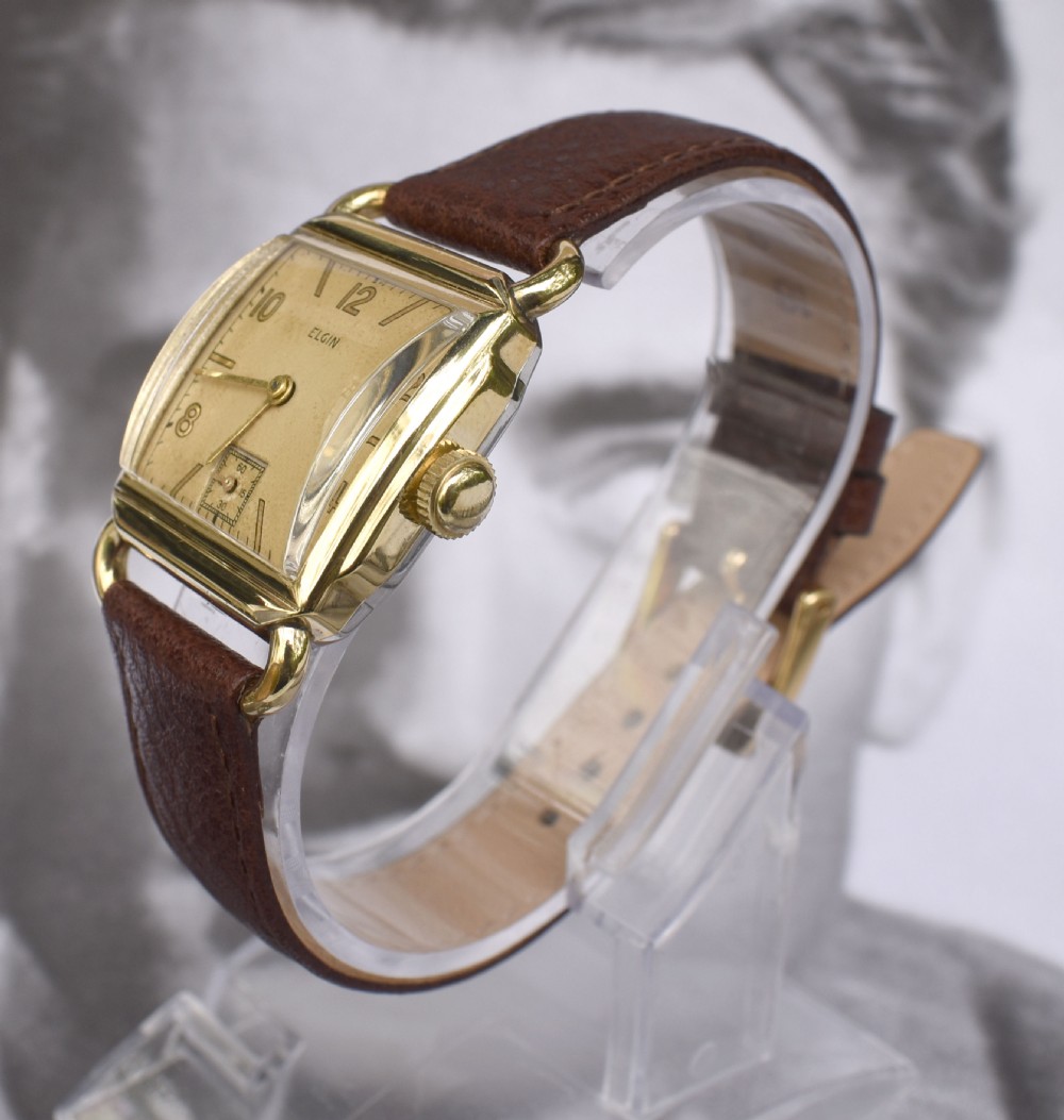 A square gold-filled vintage Elgin gents wristwatch with a champagne dial, gold Arabic numerals, sub-seconds dial, and a dark brown leather strap. View III