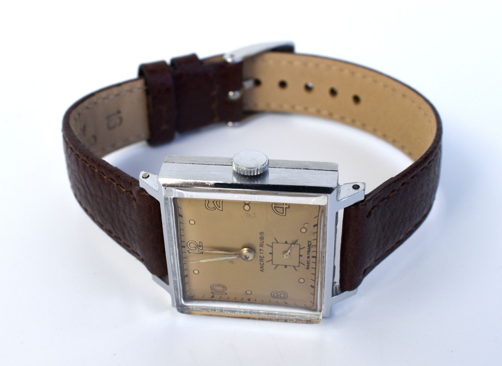 An Art Deco gents mechanical wristwatch featuring a square silver-toned case, cream dial with Arabic numerals, and a brown leather strap. View VIII
