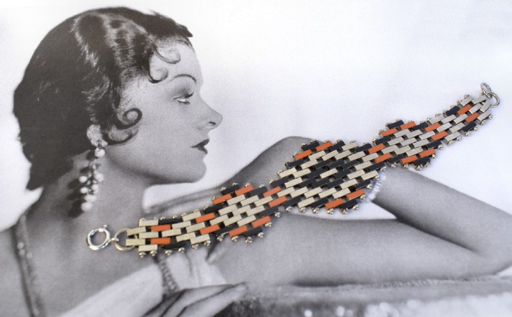 An Art Deco bracelet constructed with silver-tone chrome, black, and orange rectangular links arranged in a staggered brickwork motif.