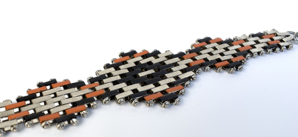 An Art Deco bracelet constructed with silver-tone chrome, black, and orange rectangular links arranged in a staggered brickwork motif. View III