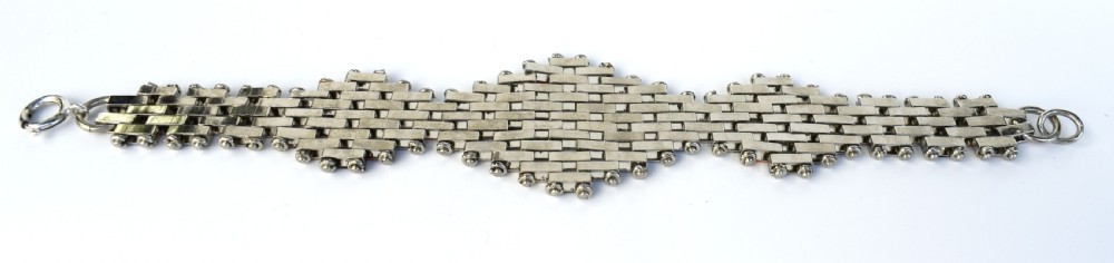 An Art Deco bracelet constructed with silver-tone chrome, black, and orange rectangular links arranged in a staggered brickwork motif. View VII