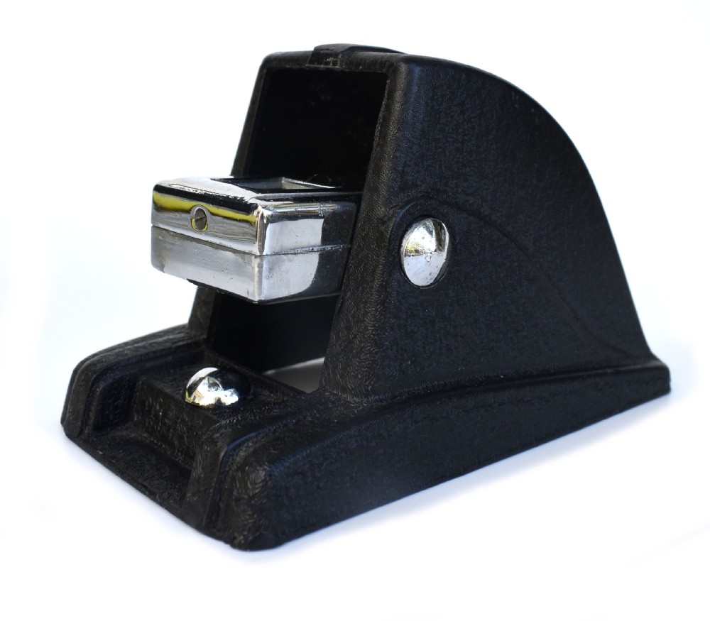 A black textured Bakelite and chrome Art Deco perpetual desk calendar featuring a geometric stepped frame with the text BRITISH MADE displayed. View V