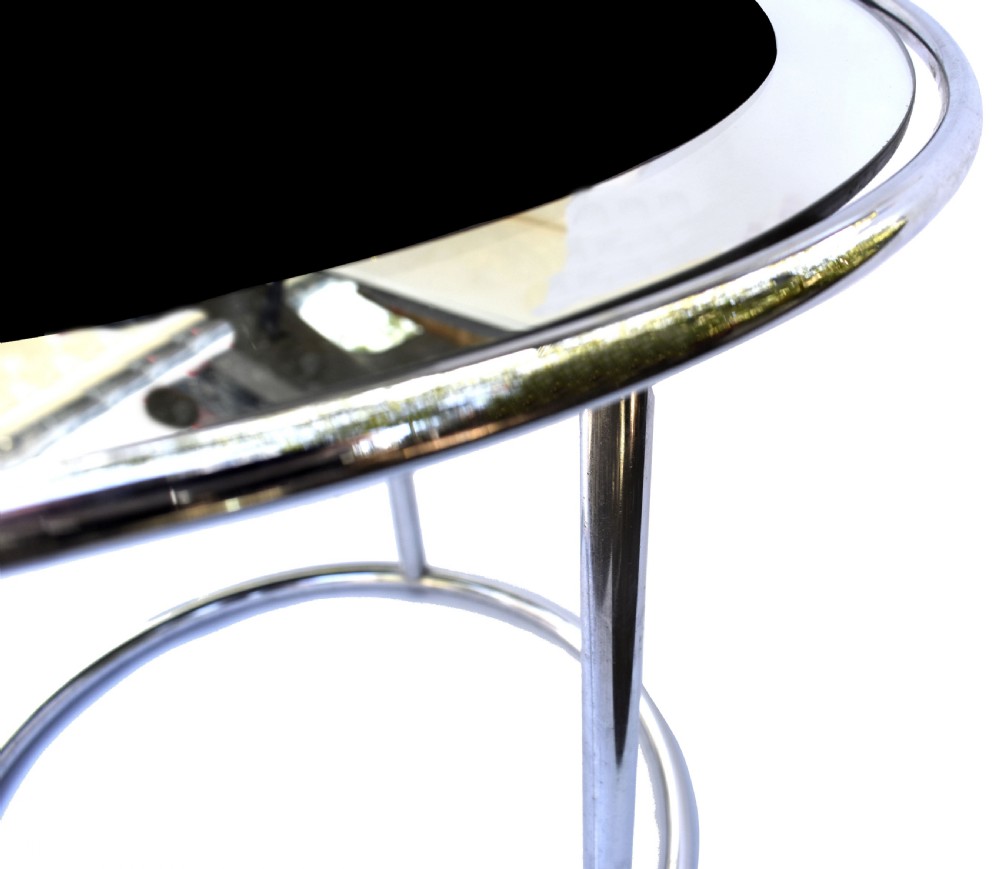 A circular Art Deco occasional table featuring a reflective chrome tubular metal frame and a black and clear glass top. View V