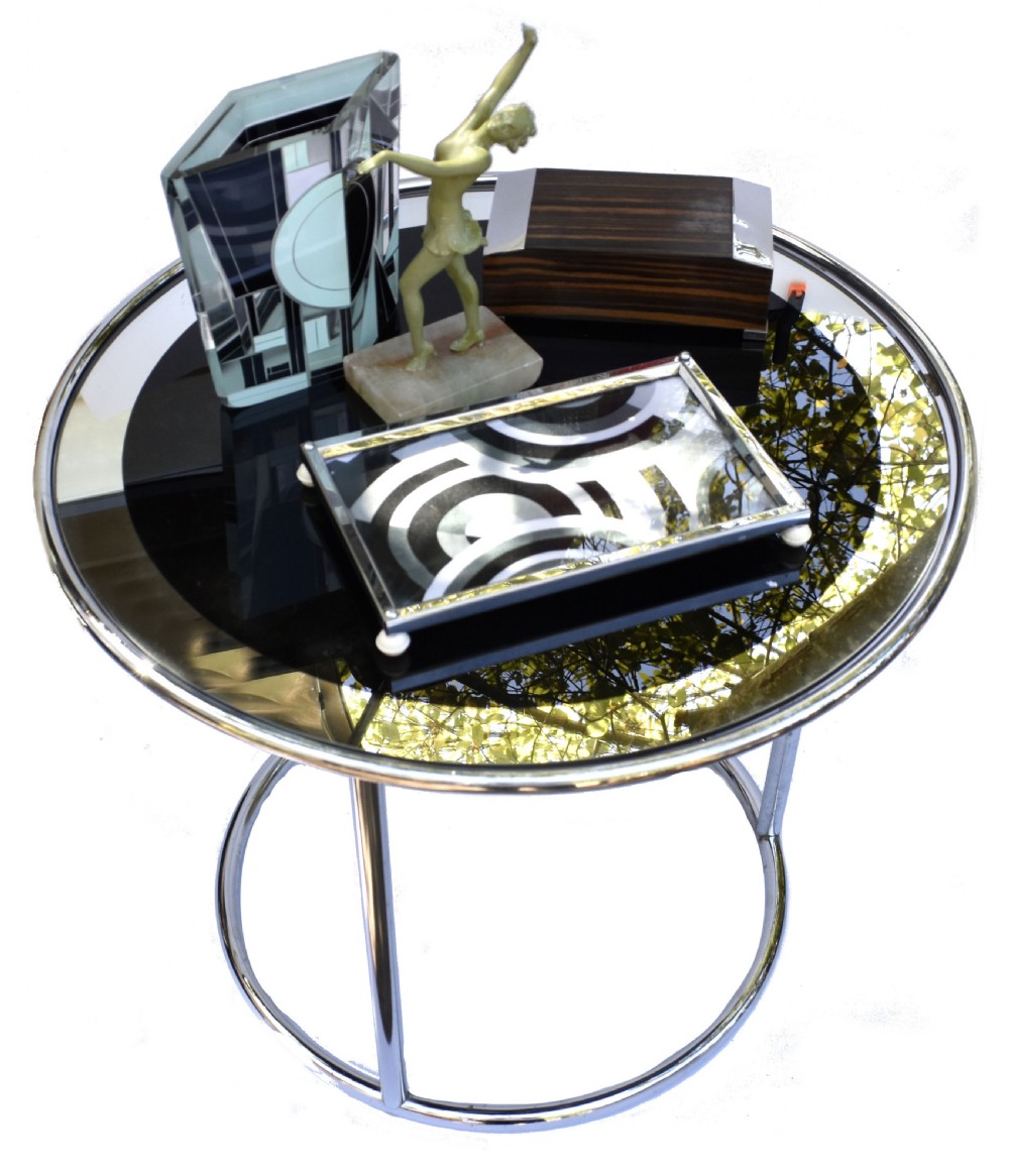 A circular Art Deco occasional table featuring a reflective chrome tubular metal frame and a black and clear glass top. View IX
