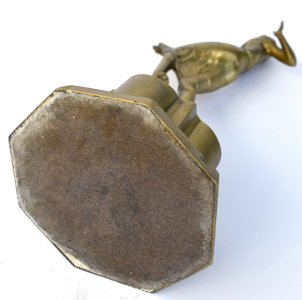 An Art Deco gilded spelter table lighter depicting a female dancer in a dynamic pose atop a stepped geometric pedestal base. View III