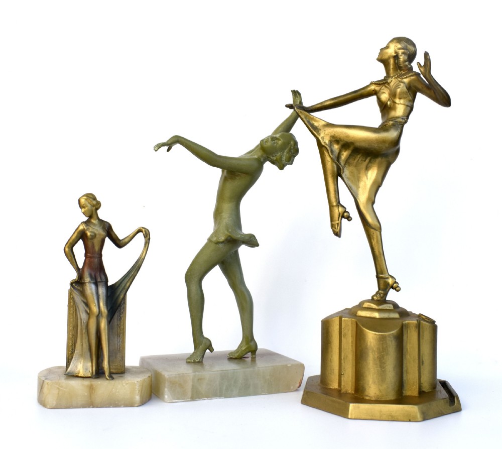 An Art Deco spelter figurine of a draped female dancer standing on a rectangular cream onyx base. View II