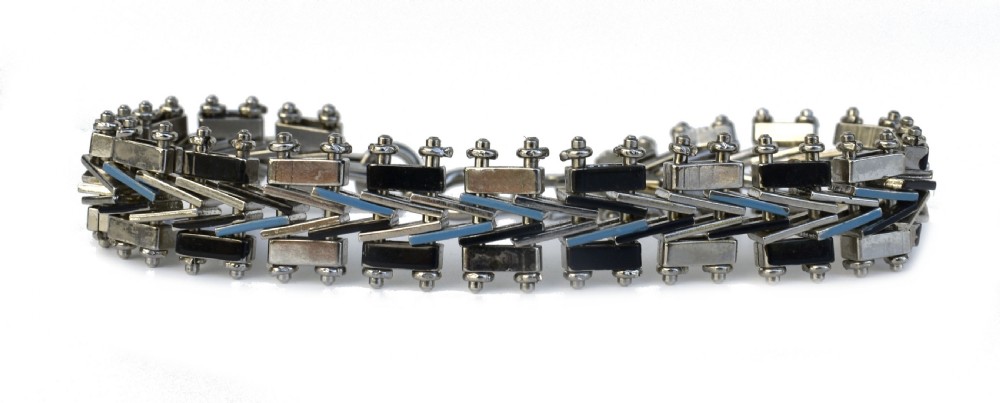 An Art Deco chrome-plated link bracelet featuring geometric black and light blue enamel accents in a machine-age pattern.