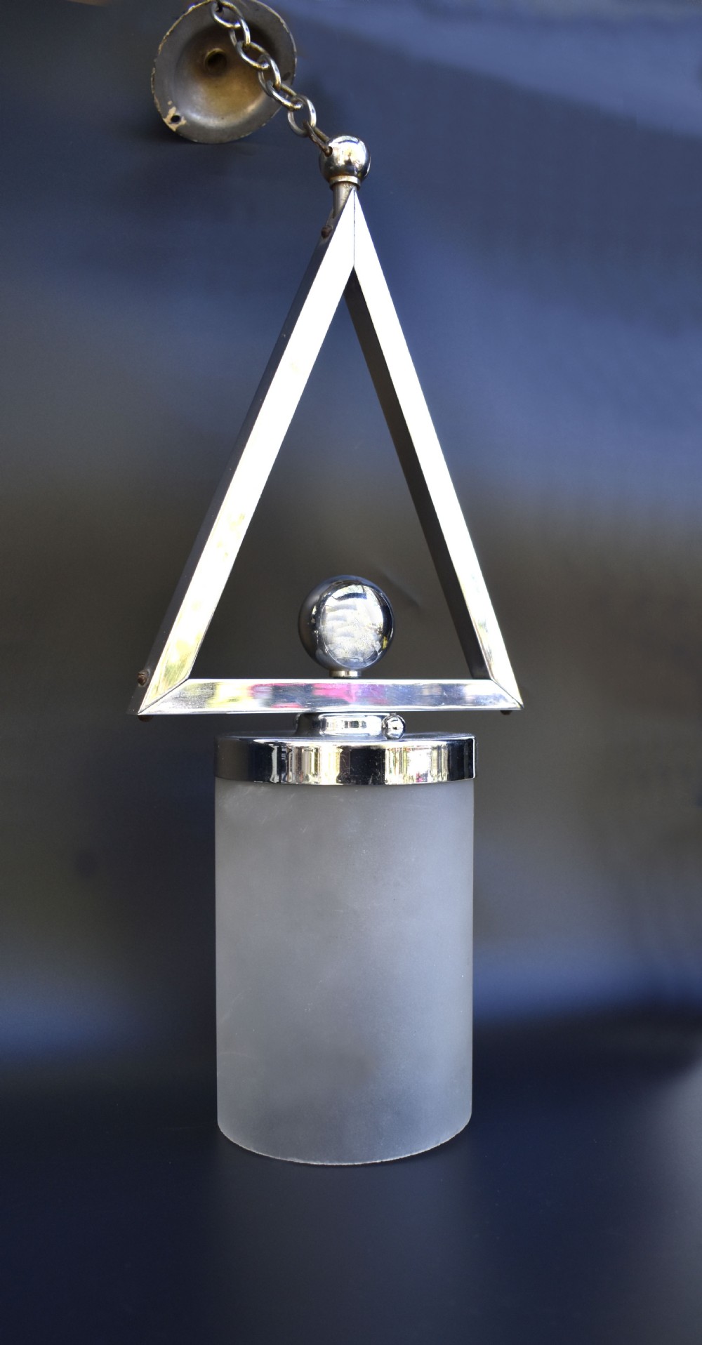 An Art Deco pendant ceiling light featuring a polished chrome triangular suspension frame and spherical detailing above a cylindrical frosted glass shade. View III