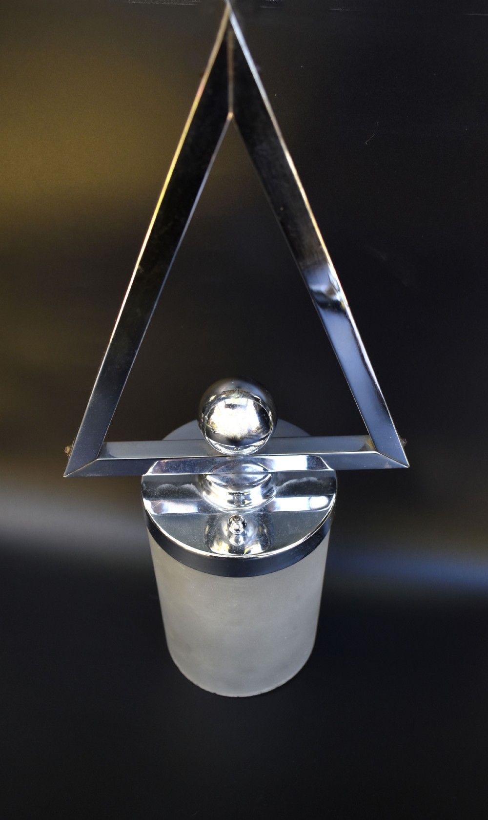 An Art Deco pendant ceiling light featuring a polished chrome triangular suspension frame and spherical detailing above a cylindrical frosted glass shade. View IV