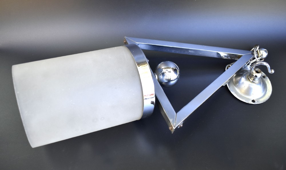 An Art Deco pendant ceiling light featuring a polished chrome triangular suspension frame and spherical detailing above a cylindrical frosted glass shade. View V