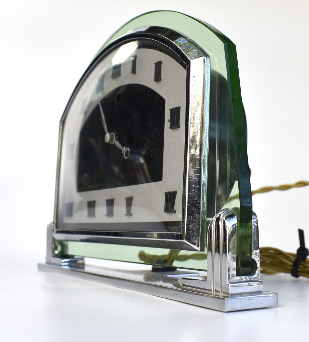 An Art Deco arched green glass mantel clock featuring a chrome frame and black Roman numerals on a two-tone dial. View III