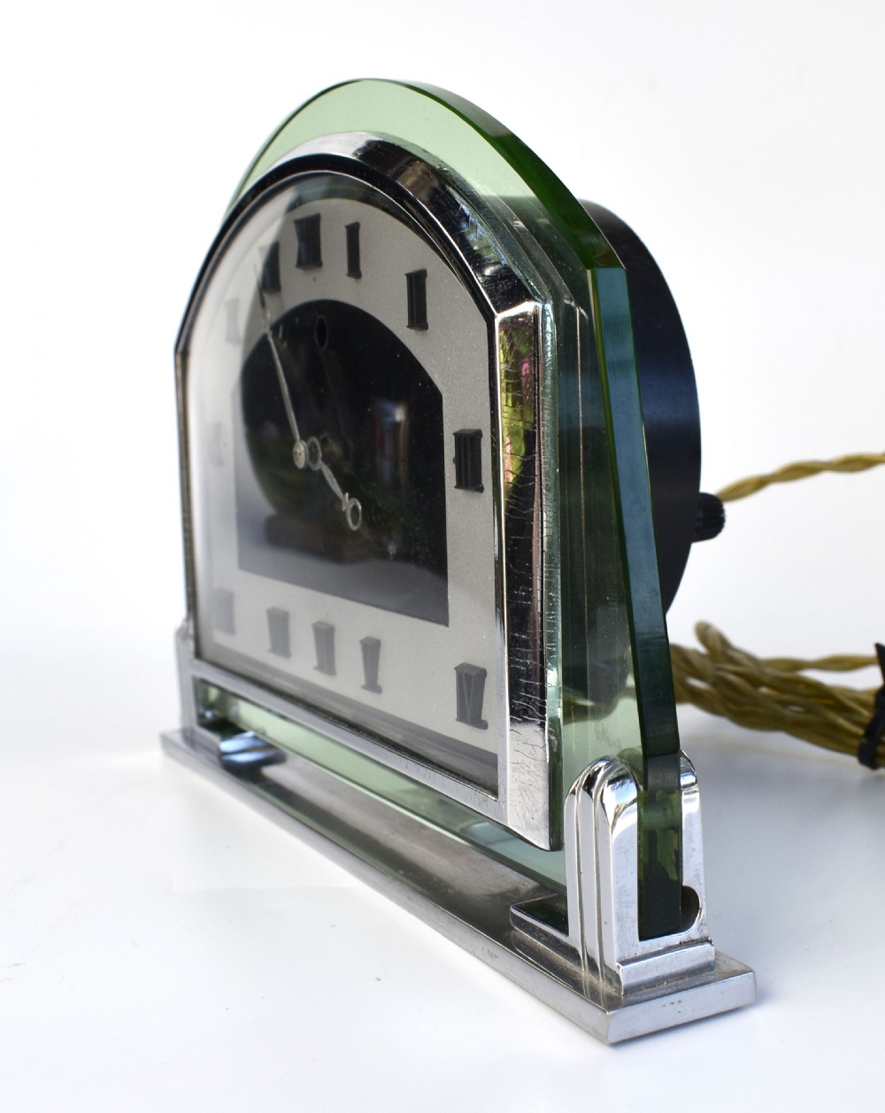 An Art Deco arched green glass mantel clock featuring a chrome frame and black Roman numerals on a two-tone dial. View IV