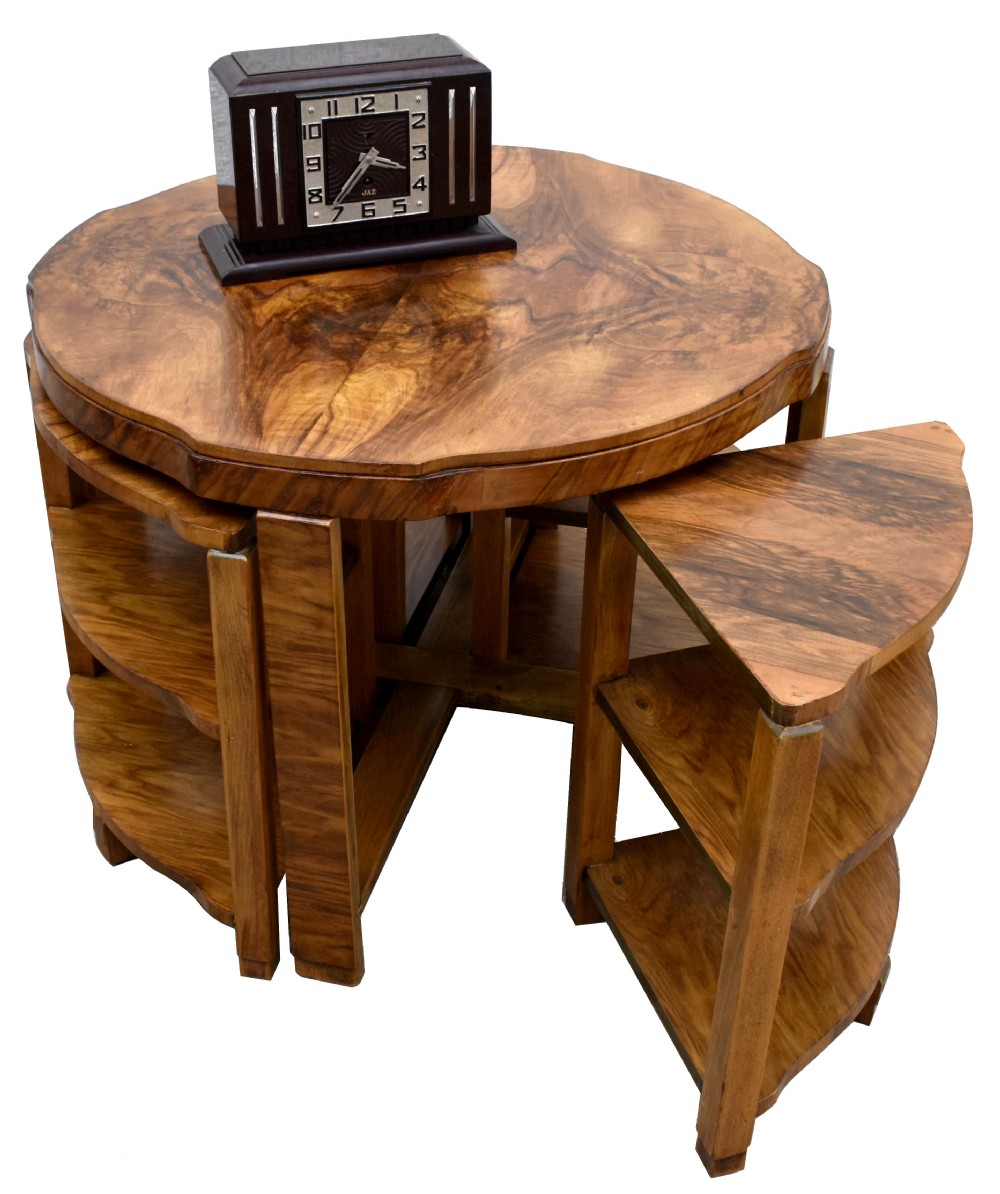 An Art Deco circular walnut coffee table housing four matching triangular side tables beneath its top.