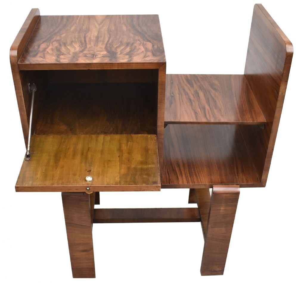An Art Deco walnut telephone table featuring asymmetrical shelving, a small drop-down cabinet with figured grain, and straight slab legs, circa 1930. View VII