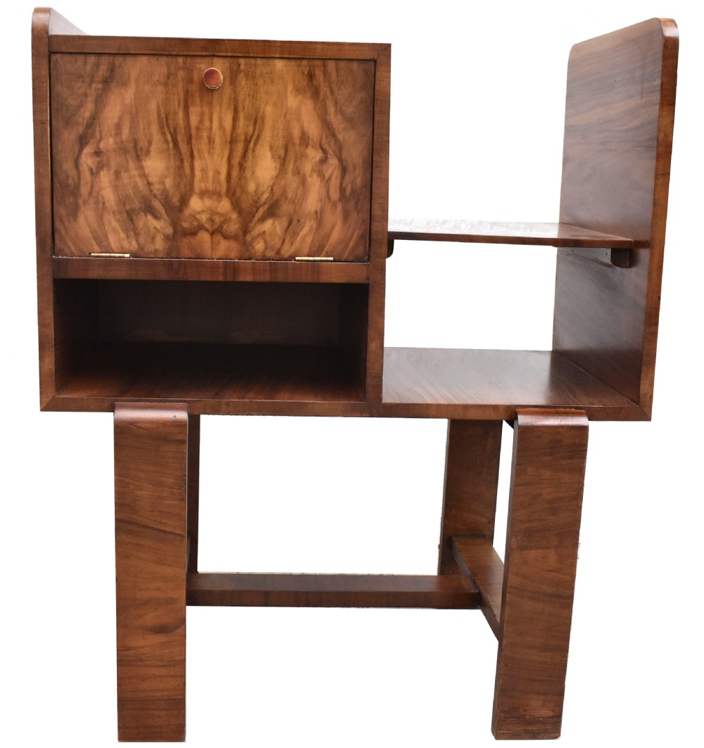 An Art Deco walnut telephone table featuring asymmetrical shelving, a small drop-down cabinet with figured grain, and straight slab legs, circa 1930. View VIII