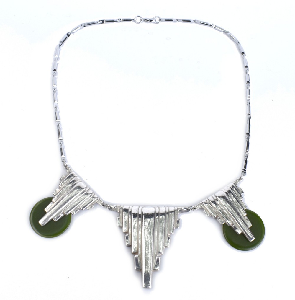 An Art Deco chrome link necklace featuring three stepped geometric metal pendants accented with circular green Bakelite discs. View V