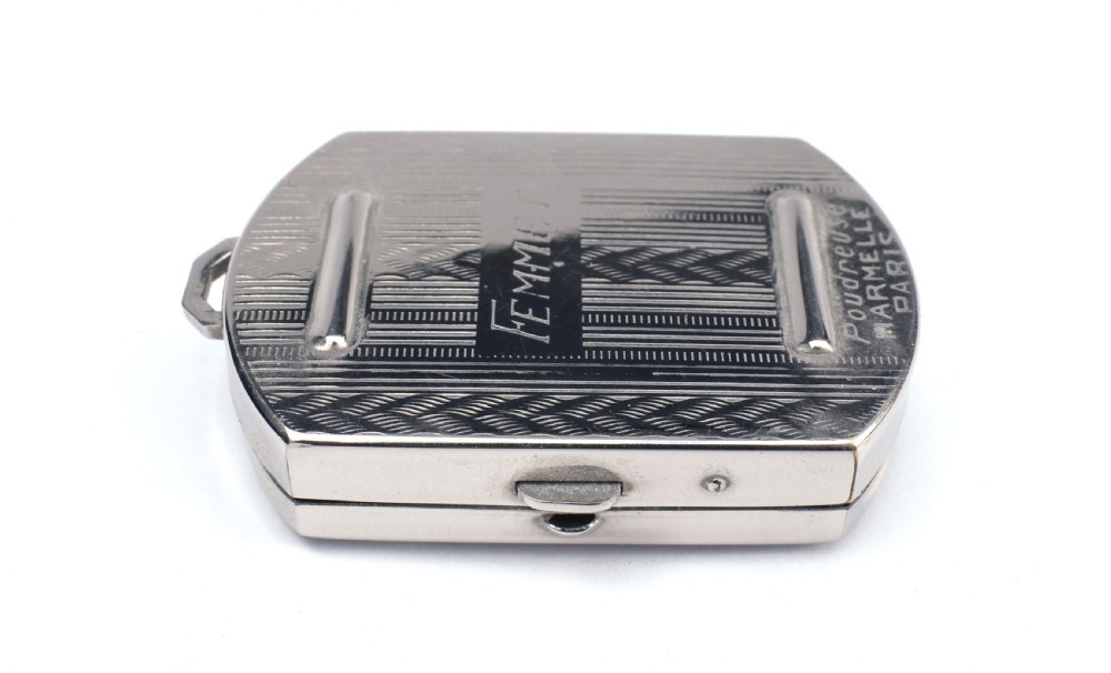 An Art Deco rectangular chrome powder compact decorated with black, green, and white geometric enamel inlay. View II