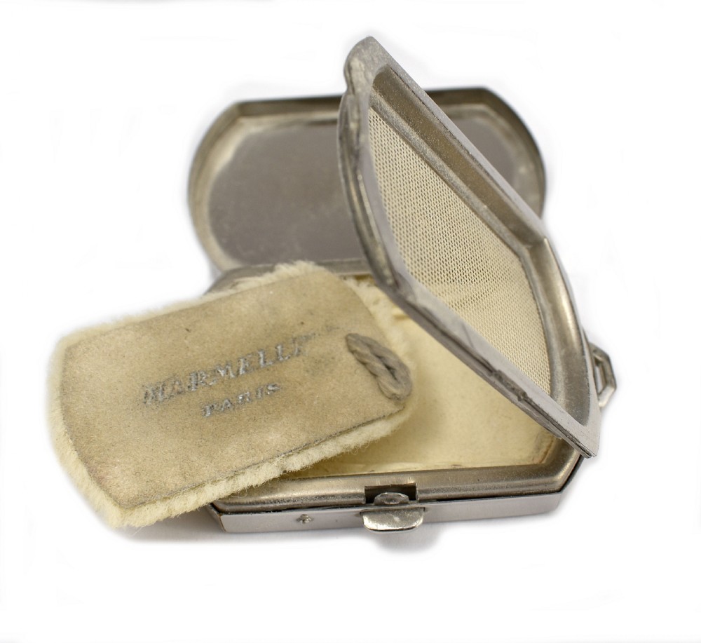 An Art Deco rectangular chrome powder compact decorated with black, green, and white geometric enamel inlay. View VI