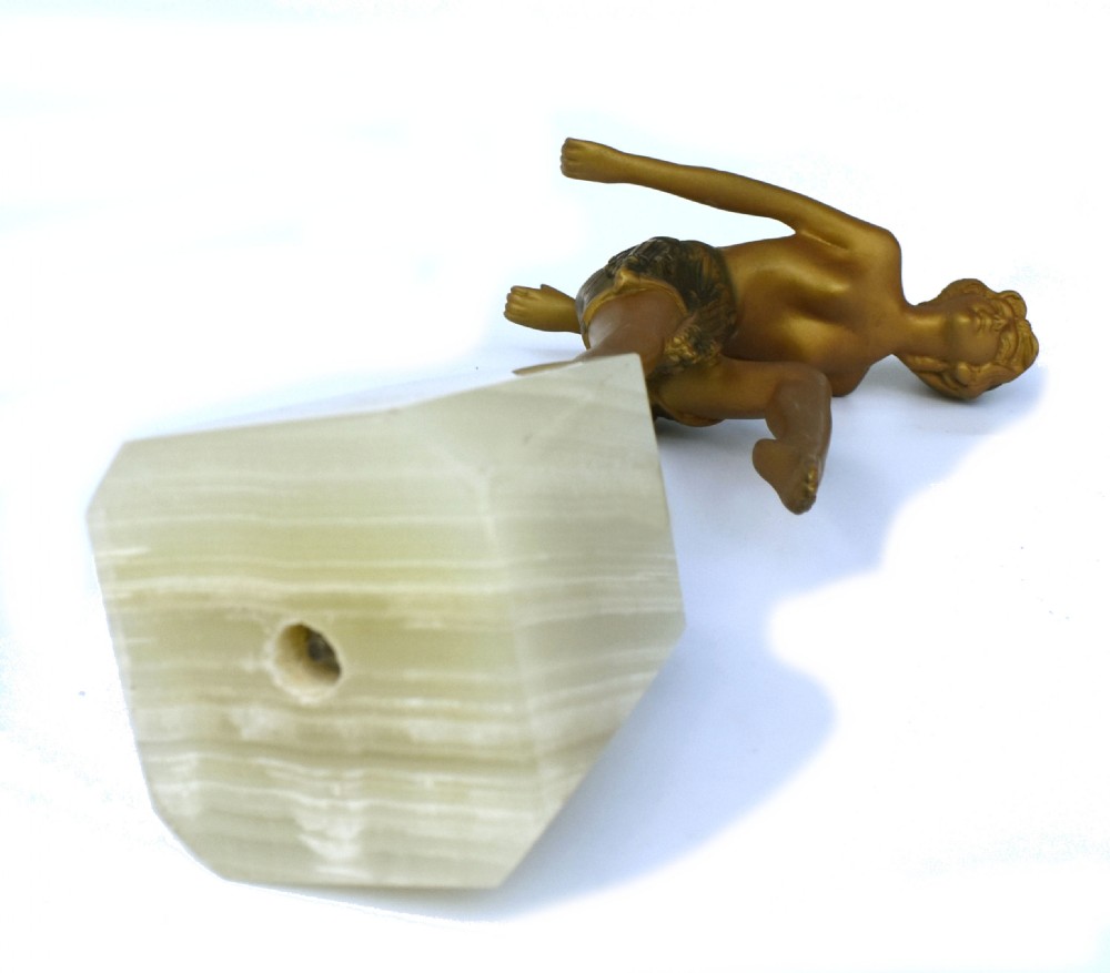 An Art Deco spelter statue depicting a female dancer posed on one leg atop a square cream onyx base. View III