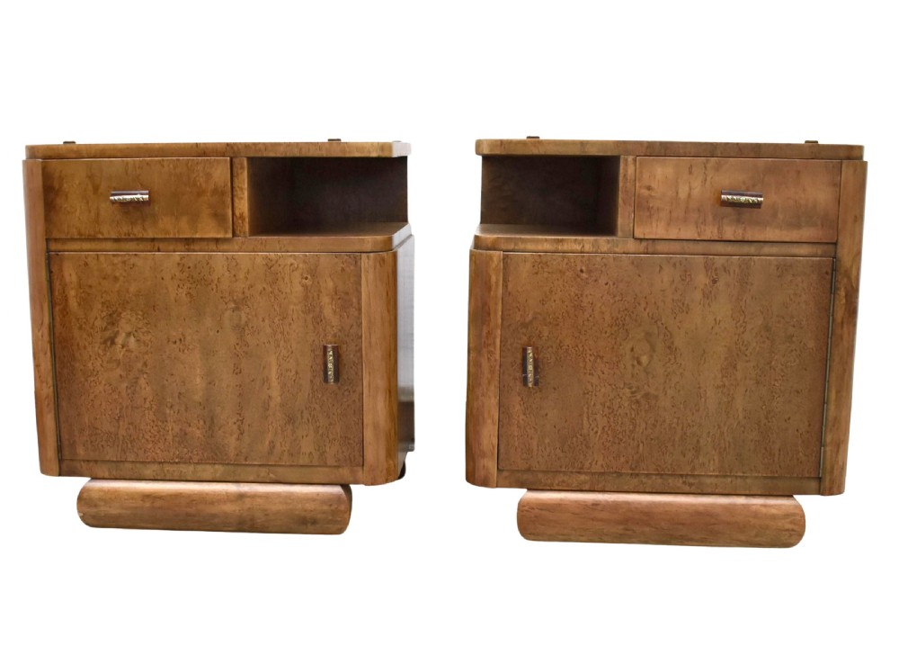 A matching pair of 1930s Art Deco burr elm bedside cabinets featuring top drawers, open compartments, single-door cupboards, and rounded plinth bases.