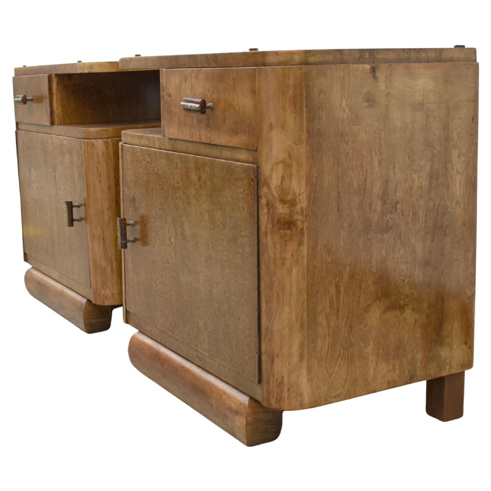 A matching pair of 1930s Art Deco burr elm bedside cabinets featuring top drawers, open compartments, single-door cupboards, and rounded plinth bases. View II