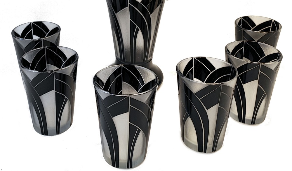 An Art Deco black and frosted glass drinks set featuring a tall jug and six matching tumblers decorated with geometric black arch patterns. View II