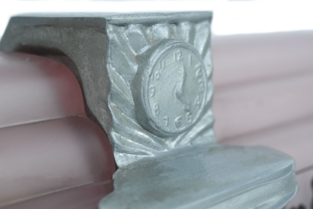 An Art Deco style lamp featuring a stepped pink frosted glass body decorated with black silhouetted figures dining inside windows, framed by a silver-coloured cast metal base and central architectural doorway with a clock motif. View XIV