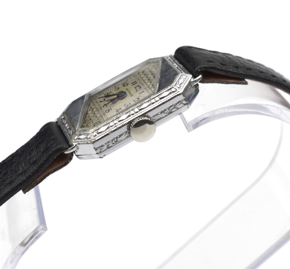An Art Deco ladies wristwatch featuring an octagonal engraved 14k white gold case, a patterned geometric dial, blue hands, and a black leather strap. View IV