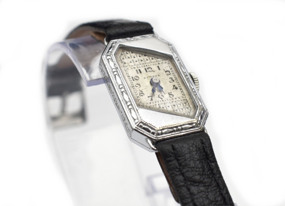 An Art Deco ladies wristwatch featuring an octagonal engraved 14k white gold case, a patterned geometric dial, blue hands, and a black leather strap. View VI