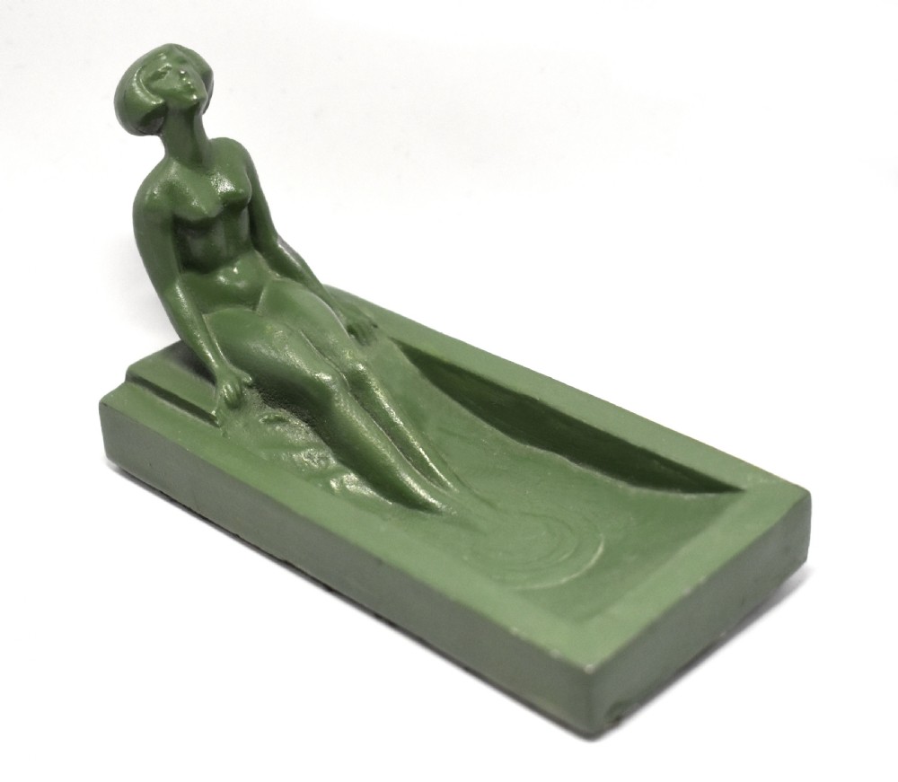 A green Art Deco spelter pin dish featuring a reclining female figure resting along the edge of a small rectangular tray. View IV