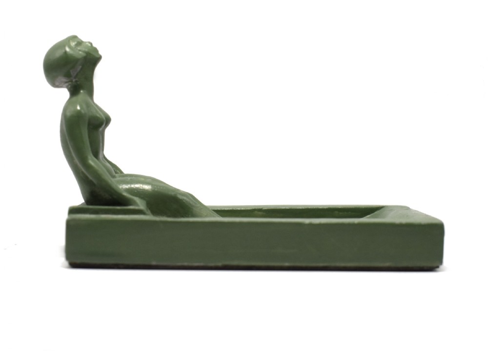 A green Art Deco spelter pin dish featuring a reclining female figure resting along the edge of a small rectangular tray. View VII